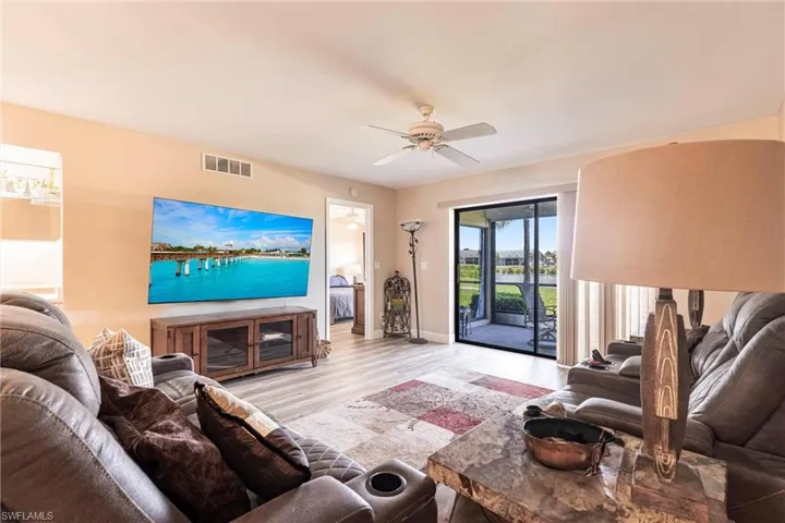 Living room with light wood-style floors and a ceiling fan