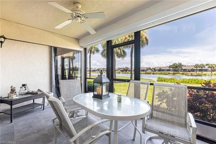 Sunroom / solarium with a textured wall, ceiling fan, a textured ceiling, a water view, and outdoor dining area