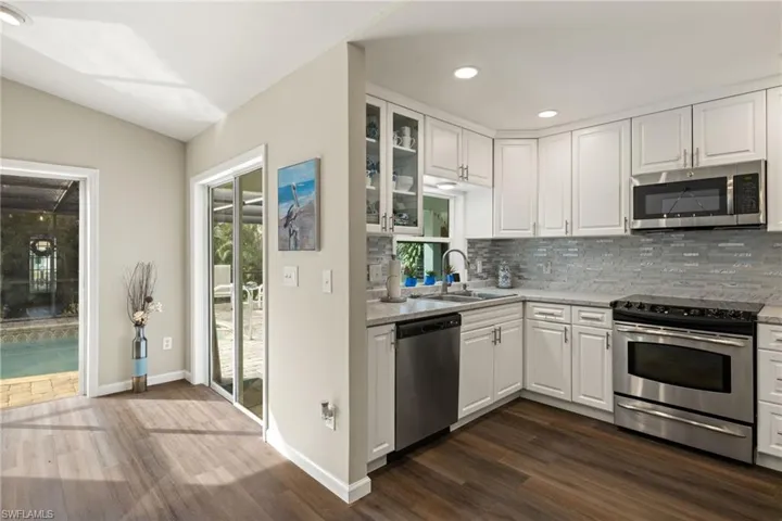 Bedroom with dark hardwood / wood-style flooring, ceiling fan, and ensuite bath