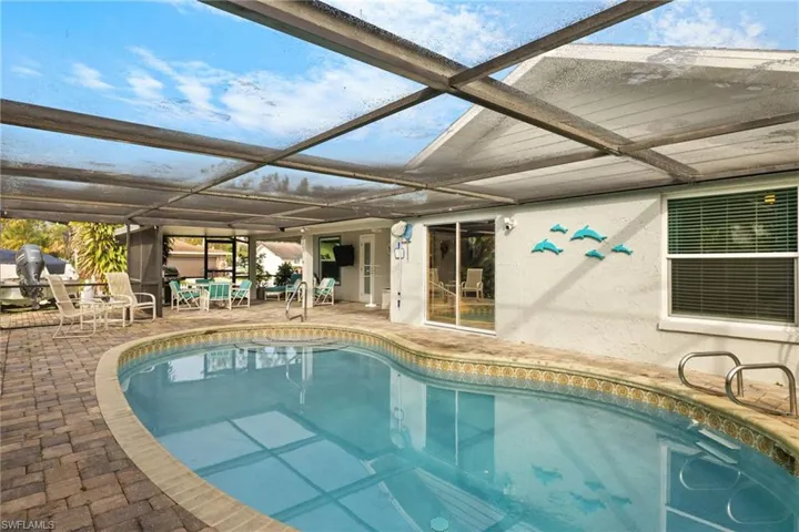 View of swimming pool featuring a patio area and glass enclosure