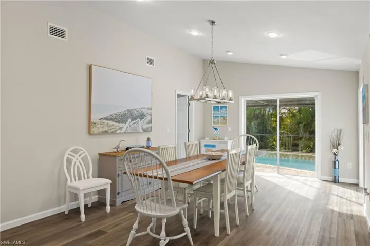 Dining space with lofted ceiling, dark wood-type flooring, and a chandelier