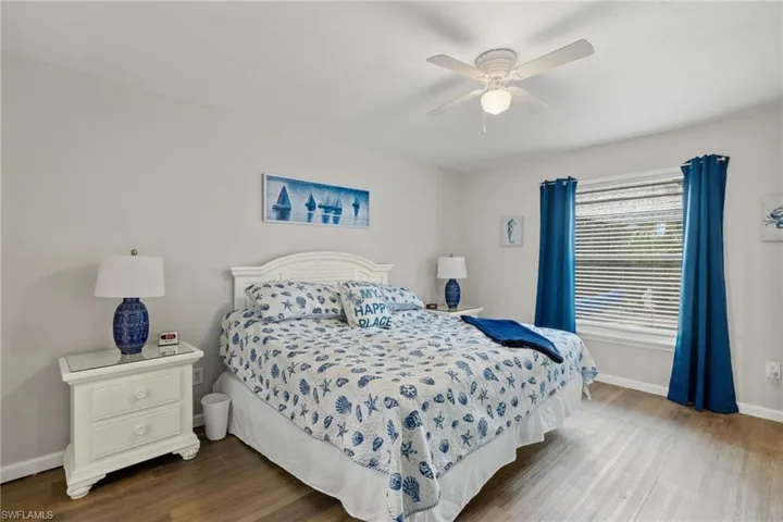 Bedroom with hardwood / wood-style floors, ceiling fan, and ensuite bathroom