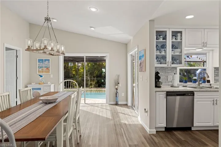 Dining area featuring lofted ceiling, a chandelier, and dark hardwood / wood-style flooring