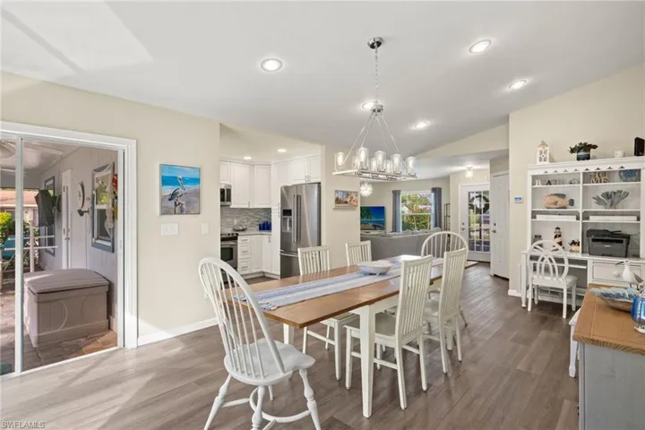 Dining room featuring lofted ceiling, dark hardwood / wood-style floors, sink, and a notable chandelier