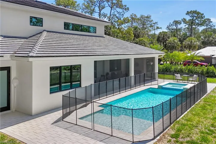 View of pool with a patio area, a sunroom, and a pool with connected hot tub