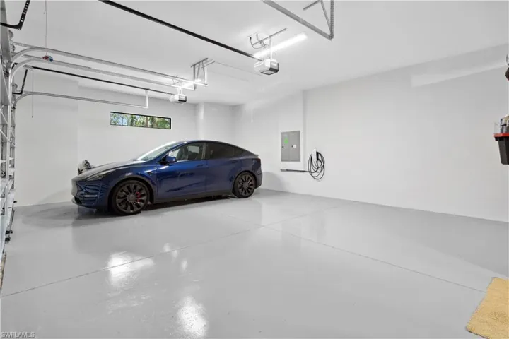 Garage featuring electric panel and a garage door opener