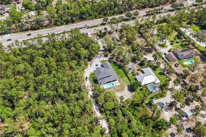 Aerial view of property and surrounding area featuring nearby suburban area