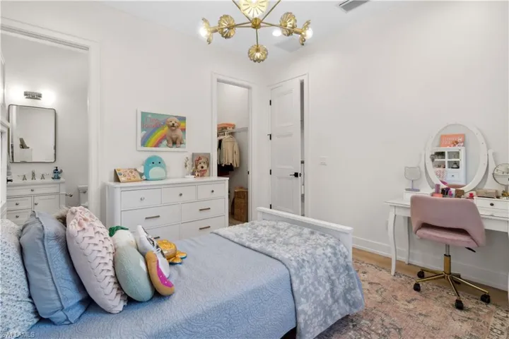 Bedroom with a chandelier, a sink, baseboards, and light wood-style floors