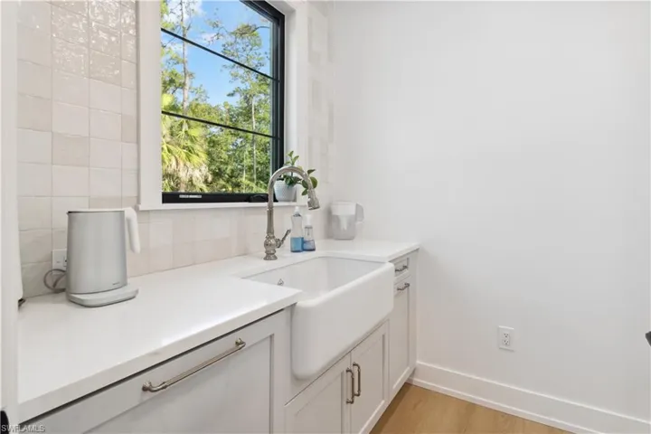 Bathroom with vanity, baseboards, healthy amount of natural light, and wood finished floors
