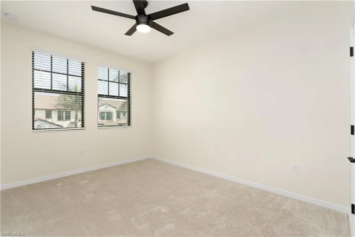 Unfurnished room with light colored carpet, ceiling fan, and baseboards