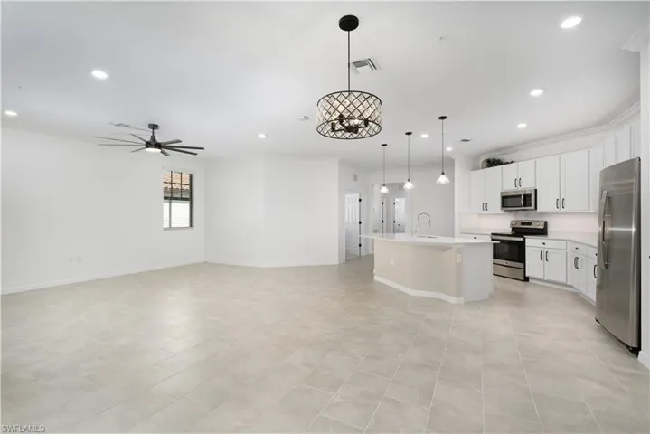 Kitchen featuring visible vents, appliances with stainless steel finishes, open floor plan, and crown molding