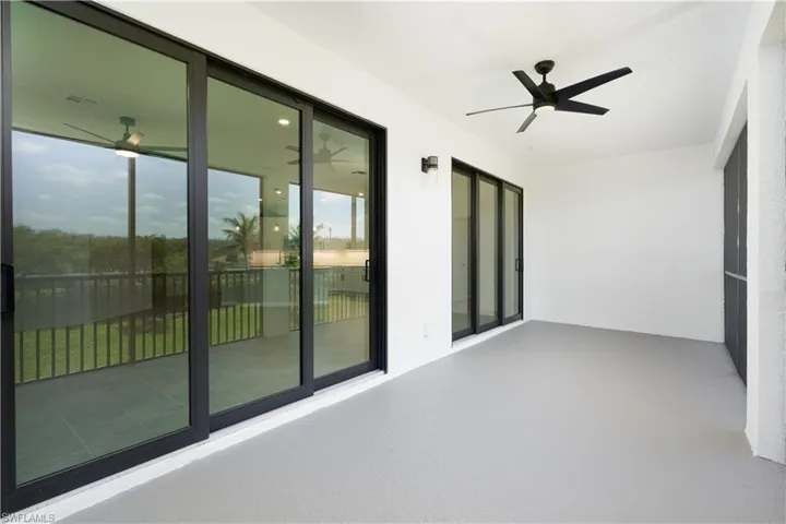 Unfurnished sunroom featuring a wealth of natural light and ceiling fan