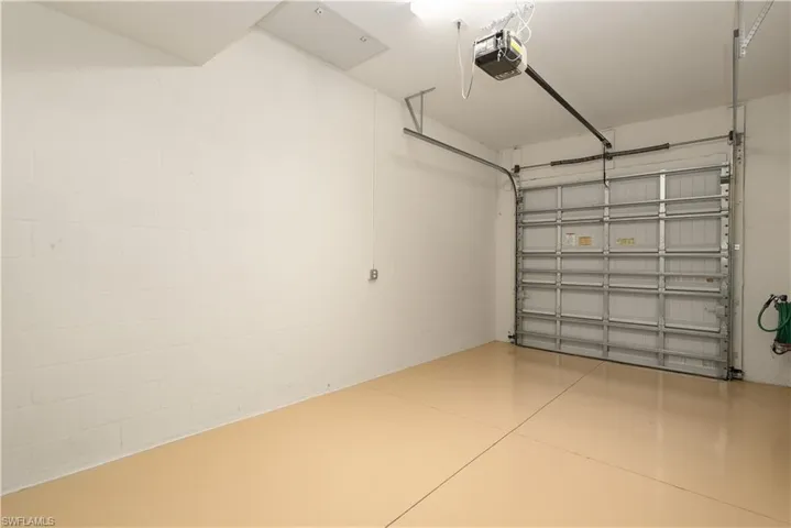Garage featuring concrete block wall and a garage door opener
