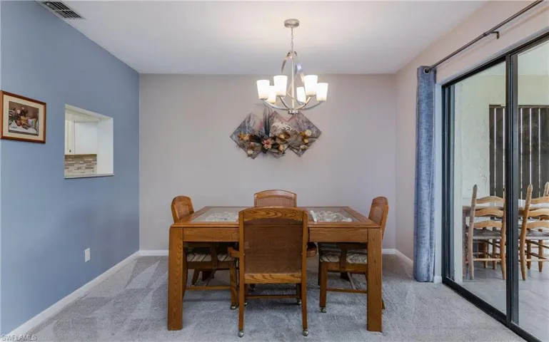 Dining room with light carpet and a notable chandelier