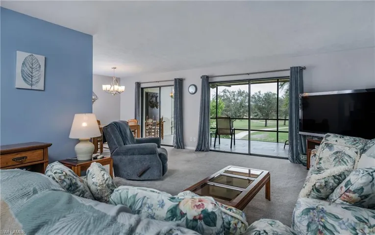 Living room with a notable chandelier and light carpet