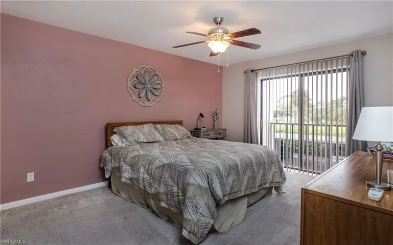 Carpeted bedroom featuring access to outside and ceiling fan