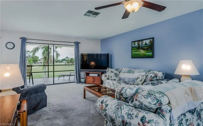 Living room featuring ceiling fan and light colored carpet