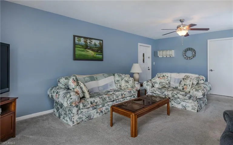 Living room featuring light carpet and ceiling fan