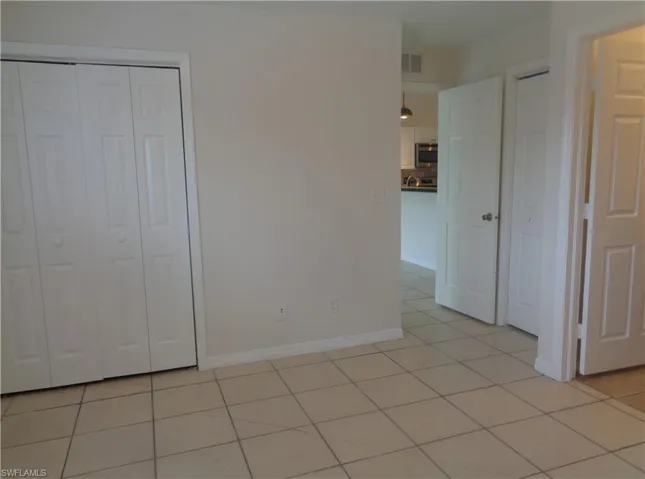 Master bedroom featuring light color tile floors and double closets
