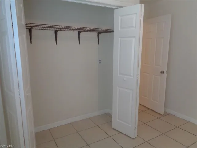 Guest bedroom 2 with closet and light patterned flooring