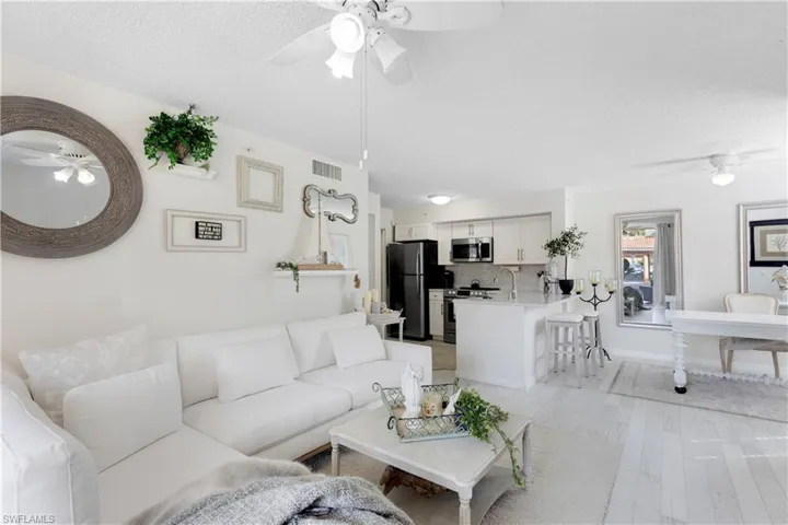 Living room featuring sink, ceiling fan, a textured ceiling, and light hardwood / wood-style flooring