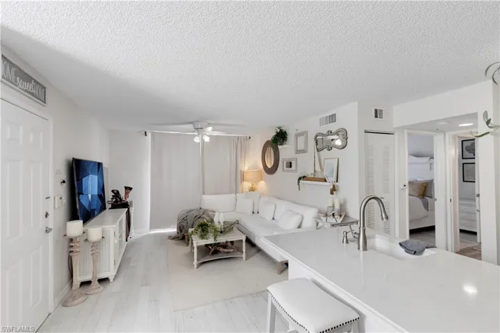 Living room featuring sink, a textured ceiling, light hardwood / wood-style floors, and ceiling fan