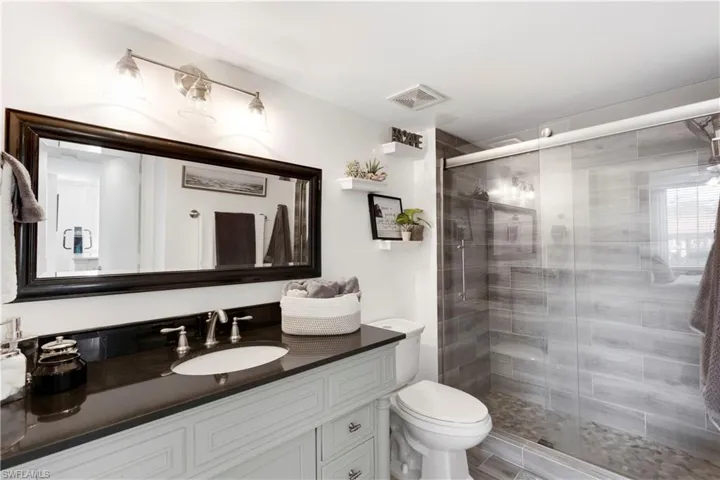 Bathroom with vanity, toilet, and walk in shower