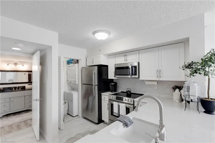 Kitchen featuring appliances with stainless steel finishes, light wood-type flooring, and white cabinets