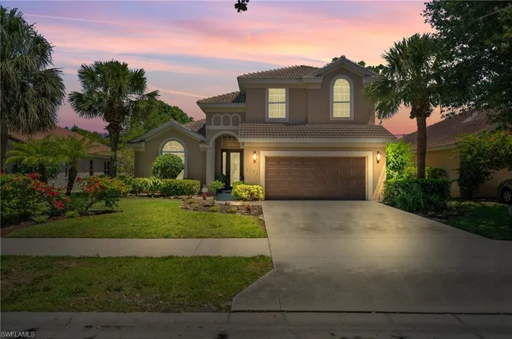 Mediterranean / spanish-style home with concrete driveway, a garage, stucco siding, a yard, and a tile roof