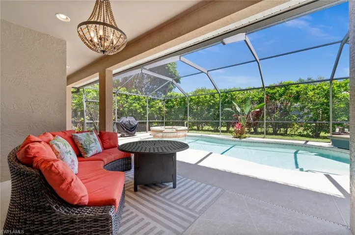 View of pool with glass enclosure, a sunroom, a patio, grilling area, and a pool with connected hot tub