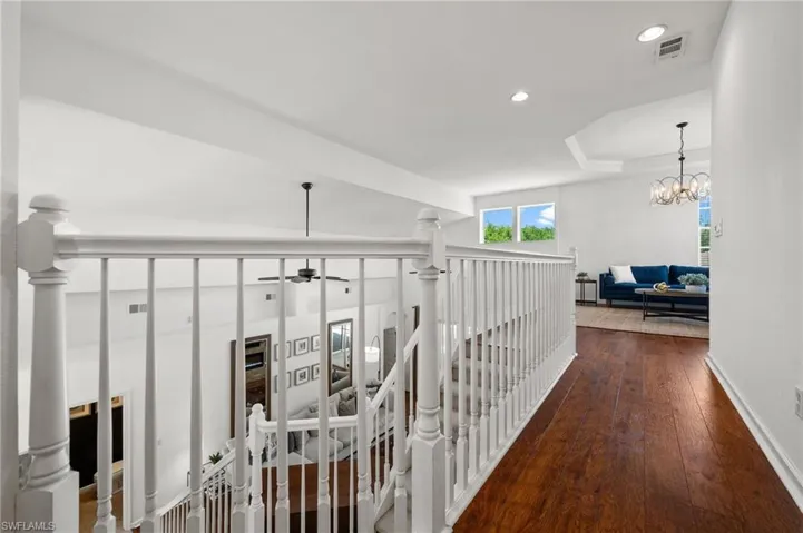 Hallway featuring an upstairs landing, dark wood-type flooring, recessed lighting, and a chandelier