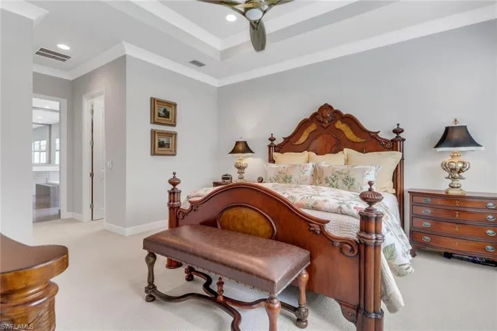 Bedroom featuring crown molding, baseboards, visible vents, and light colored carpet