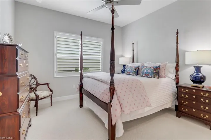 Carpeted bedroom with ceiling fan and baseboards
