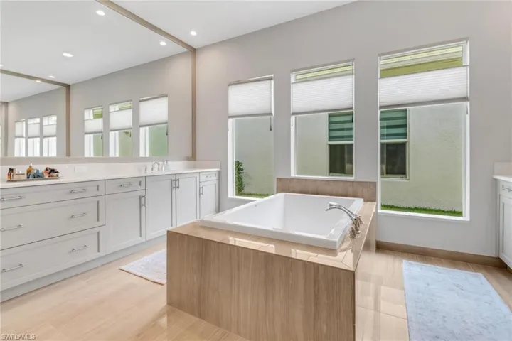 Full bath featuring a garden tub, vanity, and recessed lighting