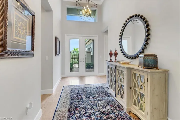 Foyer with a notable chandelier, french doors, a high ceiling, and baseboards
