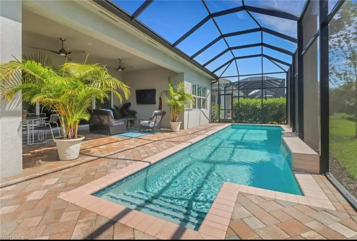Pool featuring a lanai, ceiling fan, and a patio
