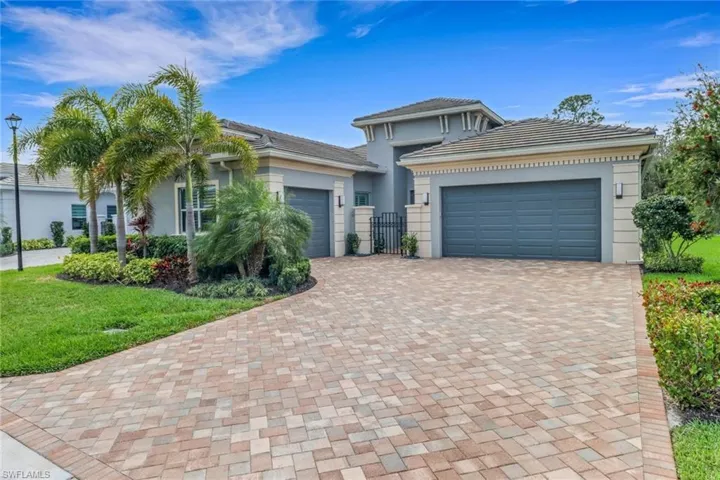 View of front facade with a garage, decorative driveway, and stucco siding