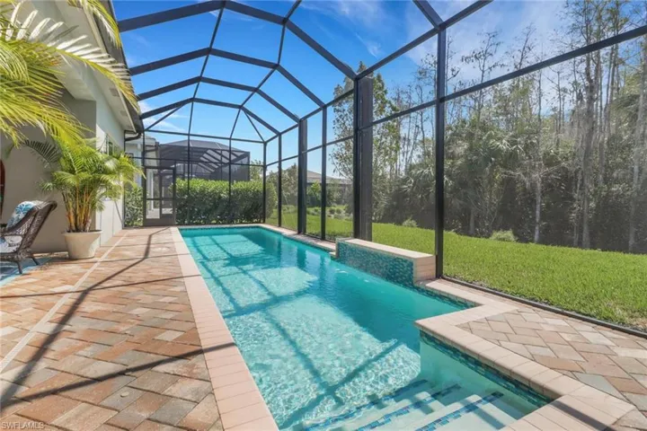 Outdoor pool featuring a lanai, a patio area, and a yard