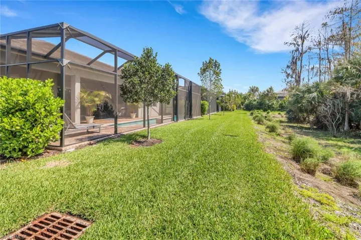 View of yard with a lanai and an outdoor pool