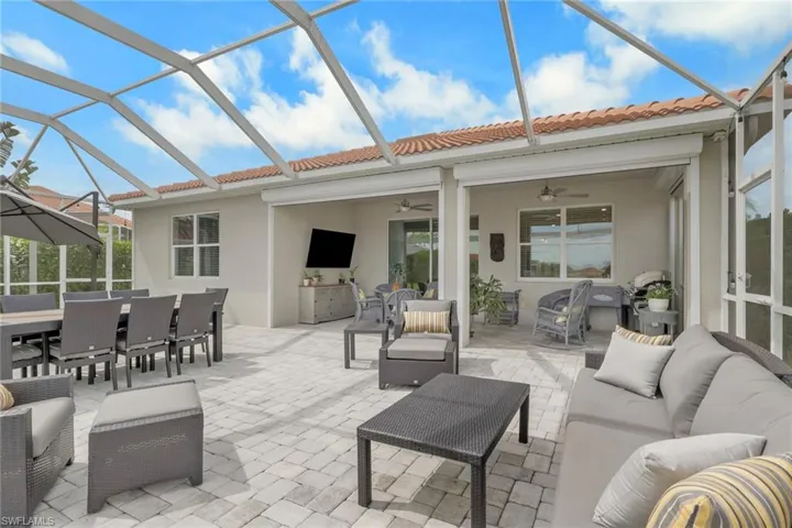 View of lanai, with an outdoor living / dining area, ceiling fans and hurricane screens