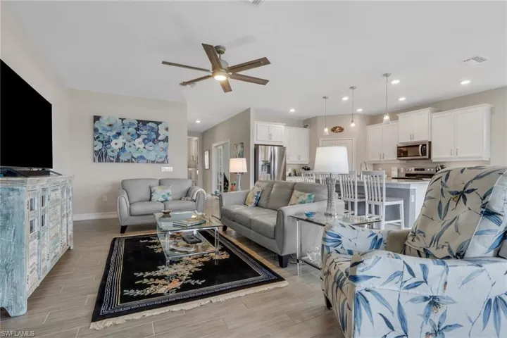 Living room featuring tiled floor, a ceiling fan, and recessed lighting