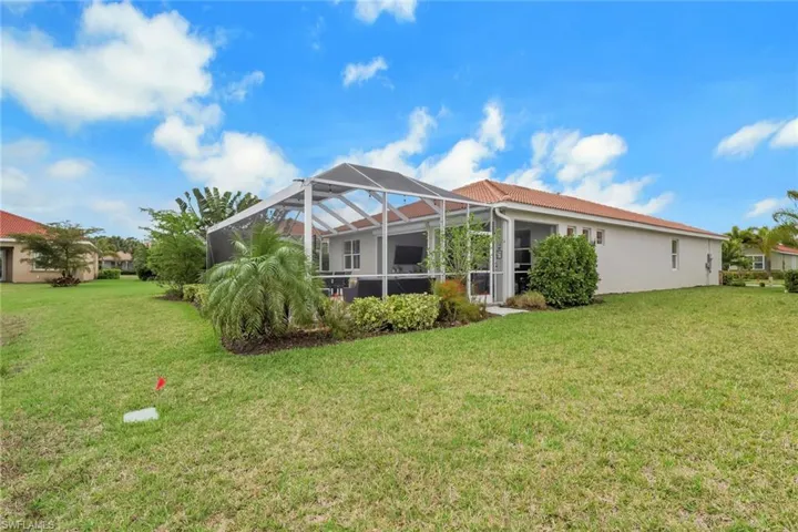 Back of property featuring professional landscaping