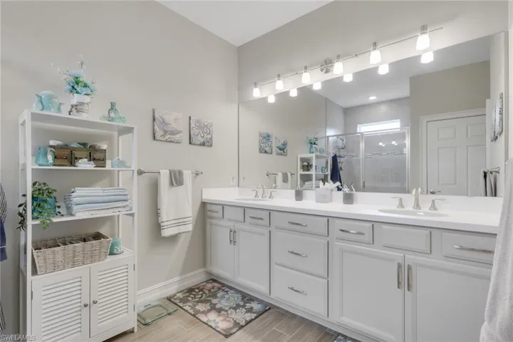 Full primary bathroom featuring double vanity, and full mirror