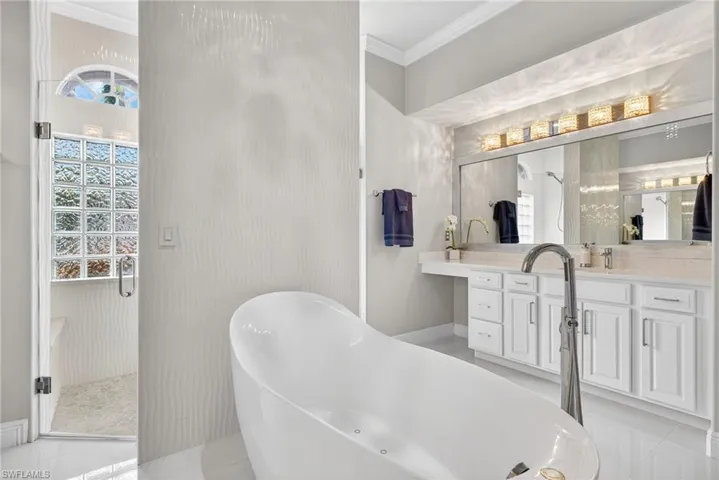 Closer view of bubbler tub, walk-through shower and second vanity.