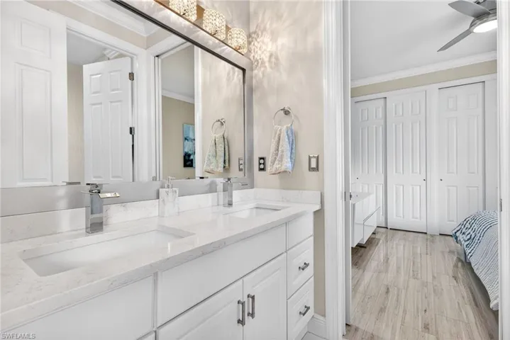 Jack and Jill bathroom leading into third bedroom.  Features white vanity with double sinks and quartz countertops.