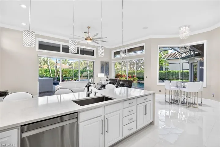 View from kitchen looking into family room, casual dining area and outdoor lanai.  Picture window, dual sliders and transom windows makes the area bright and open.