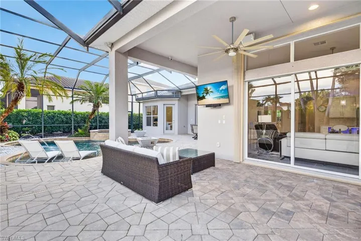 View of outdoor living area with pool in the distance.