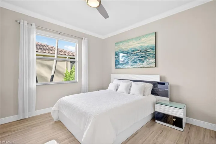Second Bedroom with tile plank flooring, crown molding and ceiling fan.