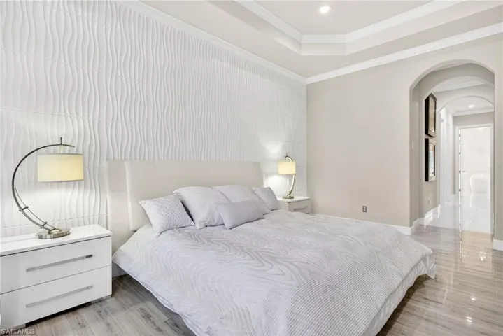 Primary Bedroom with arched walkways leading to two large walk-in closets and spa inspired bathroom.