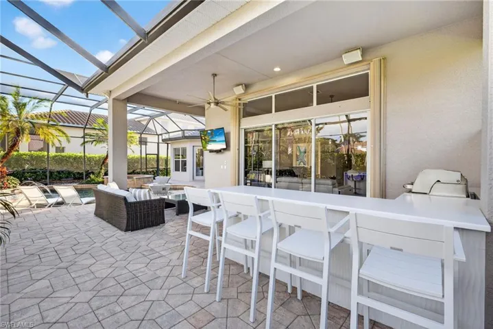 Outdoor kitchen bar featuring seating for four - perfect for relaxing and watching tv.